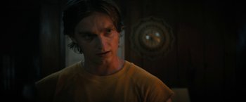 Movie still from “Fear Street: Part Two - 1978” (2021), directed by Leigh Janiak – A man with long dark hair stares into the camera; Close Up shot, Over the shoulder angle