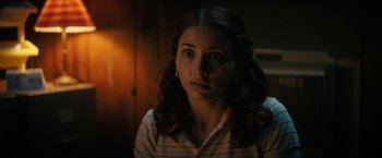 Movie still from “Fear Street: Part Two - 1978” (2021), directed by Leigh Janiak – A young woman stares at the camera with a surprised look; Close Up shot, Over the shoulder angle