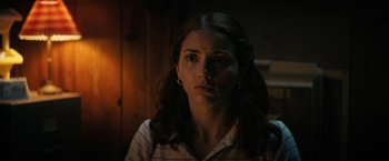 Movie still from “Fear Street: Part Two - 1978” (2021), directed by Leigh Janiak – A young woman is staring into the camera; Close Up shot, Over the shoulder angle