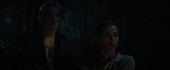 Movie still from “Fear Street: Part Two - 1978” (2021), directed by Leigh Janiak – Two people in a dark room looking at something; Medium shot, Over the shoulder angle