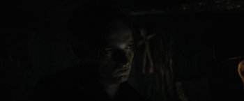 Movie still from “Fear Street: Part Two - 1978” (2021), directed by Leigh Janiak – A man is looking at the camera in the dark; Close Up shot, Over the shoulder angle