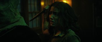 Movie still from “Fear Street: Part Two - 1978” (2021), directed by Leigh Janiak – A woman holding a knife in her mouth; Close Up shot, Over the shoulder angle