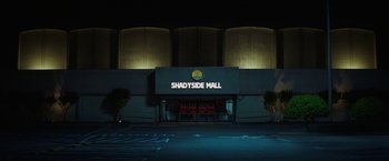 Movie still from “Fear Street: Part Two - 1978” (2021), directed by Leigh Janiak – The entrance to shadyside mall lit up at night; Extreme Wide shot, Low angle