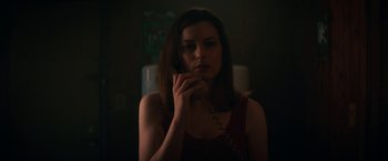 Movie still from “Fear Street: Part Two - 1978” (2021), directed by Leigh Janiak – A woman is holding a phone up to her face; Close Up shot, Low angle