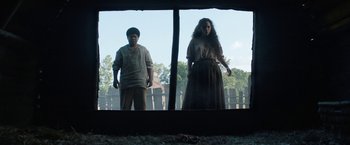 Movie still from “Fear Street: Part Two - 1978” (2021), directed by Leigh Janiak – A man and a woman standing in front of a window; Wide shot, Low angle