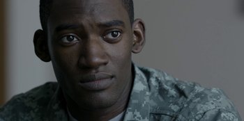 Movie still from “Black Mirror” (2011), created by Charlie Brooker – A person wearing a military uniform; Close Up shot, Over the shoulder angle