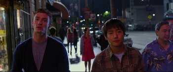 Movie still from “Friends with Benefits” (2011), directed by Will Gluck – A group of people walking down a street at night; Medium shot, Over the shoulder angle