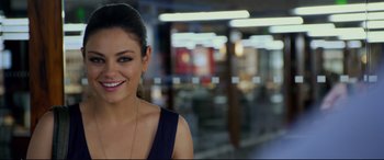 Movie still from “Friends with Benefits” (2011), directed by Will Gluck – A beautiful woman smiling for the camera in a room; Close Up shot, Over the shoulder angle