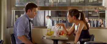 Movie still from “Friends with Benefits” (2011), directed by Will Gluck – A man and a woman sitting at a table with drinks; Medium shot, Over the shoulder angle