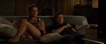 Movie still from “Friends with Benefits” (2011), directed by Will Gluck – A man and a woman sitting on a couch holding drinks; Medium shot, High angle