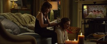 Movie still from “Friends with Benefits” (2011), directed by Will Gluck – Two women sitting on a couch with candles in the background; Medium shot, Over the shoulder angle