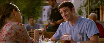 Movie still from “Friends with Benefits” (2011), directed by Will Gluck – A man sitting at a table in front of two other people; Close Up shot, Over the shoulder angle