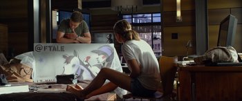 Movie still from “Friends with Benefits” (2011), directed by Will Gluck – A girl sitting in front of a painting while a man sits next to her; Wide shot, Over the shoulder angle