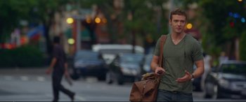 Movie still from “Friends with Benefits” (2011), directed by Will Gluck – A man walking down the street while holding a brown bag; Medium shot, Over the shoulder angle