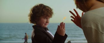 Movie still from “Friends with Benefits” (2011), directed by Will Gluck – A young boy is holding something in his hands; Medium shot, Over the shoulder angle