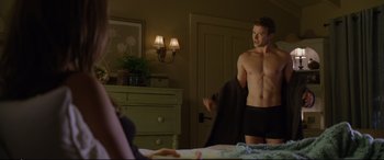 Movie still from “Friends with Benefits” (2011), directed by Will Gluck – A man in black underwear holding onto a black towel; Medium shot, Over the shoulder angle