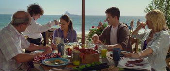 Movie still from “Friends with Benefits” (2011), directed by Will Gluck – A group of people sitting at a table with plates of food; Medium shot, Over the shoulder angle