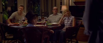 Movie still from “Friends with Benefits” (2011), directed by Will Gluck – Three people are sitting at a table with food and wine; Medium shot, Over the shoulder angle