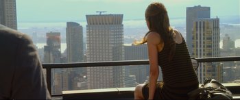 Movie still from “Friends with Benefits” (2011), directed by Will Gluck – A woman sitting on a ledge looking out over a city; Wide shot, High angle