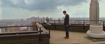 Movie still from “Friends with Benefits” (2011), directed by Will Gluck – A man in a suit and tie standing on a balcony; Wide shot, Low angle