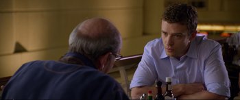 Movie still from “Friends with Benefits” (2011), directed by Will Gluck – A man sitting at a table talking to another man in front of him; Close Up shot, Over the shoulder angle