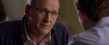 Movie still from “Friends with Benefits” (2011), directed by Will Gluck – An older man wearing glasses and a blue jacket; Close Up shot, Over the shoulder angle