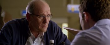 Movie still from “Friends with Benefits” (2011), directed by Will Gluck – An older man with glasses is sitting at a table; Close Up shot, Over the shoulder angle