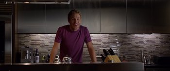 Movie still from “Friends with Benefits” (2011), directed by Will Gluck – A man standing at a counter in a kitchen; Medium shot, Over the shoulder angle