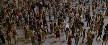 Movie still from “Friends with Benefits” (2011), directed by Will Gluck – A large group of people standing in the middle of a room; Extreme Wide shot, High angle