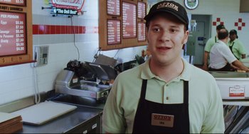 Movie still from “Funny People” (2009), directed by Judd Apatow – A man standing in front of a counter in a restaurant; Medium shot, High angle