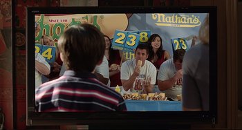 Movie still from “Funny People” (2009), directed by Judd Apatow – A group of people sitting in front of a tv; Medium shot, Over the shoulder angle