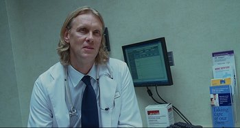Movie still from “Funny People” (2009), directed by Judd Apatow – A doctor sitting in front of a computer monitor; Close Up shot, Low angle