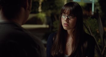 Movie still from “Funny People” (2009), directed by Judd Apatow – A young woman wearing glasses is talking to a man; Close Up shot, Over the shoulder angle