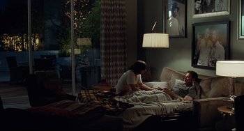 Movie still from “Funny People” (2009), directed by Judd Apatow – A man and a woman sitting in a bed; Wide shot, Over the shoulder angle
