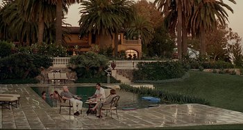 Movie still from “Funny People” (2009), directed by Judd Apatow – A group of people sitting around a swimming pool; Extreme Wide shot, High angle