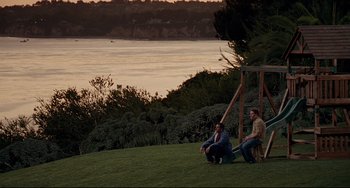 Movie still from “Funny People” (2009), directed by Judd Apatow – Two men sitting on the grass next to each other; Extreme Wide shot, High angle