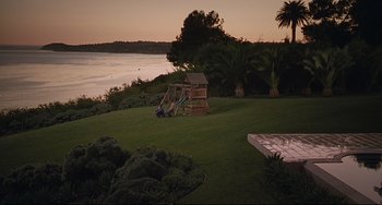 Movie still from “Funny People” (2009), directed by Judd Apatow – A small wooden play structure in the middle of a yard; Extreme Wide shot, High angle