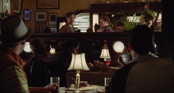 Movie still from “Funny People” (2009), directed by Judd Apatow – A group of people sitting at a table in a restaurant; Medium shot, Over the shoulder angle