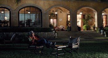 Movie still from “Funny People” (2009), directed by Judd Apatow – A man sitting on a chair in the grass; Wide shot, High angle
