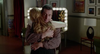 Movie still from “Funny People” (2009), directed by Judd Apatow – A man and a woman hugging in front of a mirror; Medium shot, Over the shoulder angle