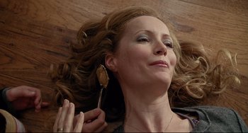 Movie still from “Funny People” (2009), directed by Judd Apatow – A woman laying on the ground with her eyes closed; Close Up shot, Overhead angle