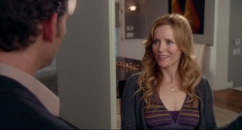 Movie still from “Funny People” (2009), directed by Judd Apatow – A woman is smiling in front of a mirror; Medium shot, Over the shoulder angle