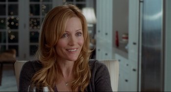 Movie still from “Funny People” (2009), directed by Judd Apatow – A woman sitting in a chair smiling for the camera; Close Up shot, Over the shoulder angle