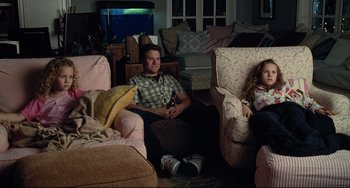 Movie still from “Funny People” (2009), directed by Judd Apatow – A man and a little girl sitting in a living room; Wide shot, High angle