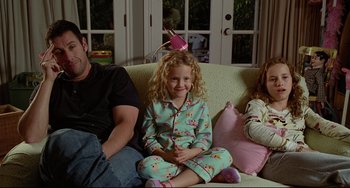 Movie still from “Funny People” (2009), directed by Judd Apatow – A man and two girls sitting on a couch; Medium shot, High angle