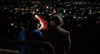 Movie still from “Funny People” (2009), directed by Judd Apatow – A man and a woman sitting in front of a city at night; Medium shot, High angle