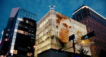 Movie still from “Gamer” (2009), directed by Mark Neveldine – A building that has a picture of a man on the side of it; Extreme Wide shot, Low angle