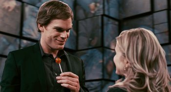 Movie still from “Gamer” (2009), directed by Mark Neveldine – A man holding a lollipop in front of a woman; Medium shot, Over the shoulder angle