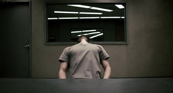 Movie still from “Gamer” (2009), directed by Mark Neveldine – A man standing in front of a large mirror; Medium shot, Low angle