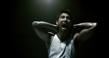 Movie still from “Gamer” (2009), directed by Mark Neveldine – A man with his hands behind his head and his mouth open; Close Up shot, Low angle